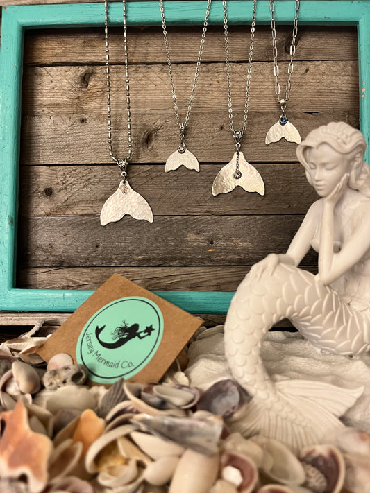Mermaid/whale Tail Necklace Hammered texture with blue crystal charm on a stainless paperclip style chain.